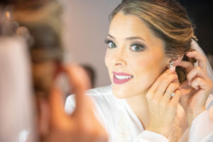 A bride getting ready in the mirror.